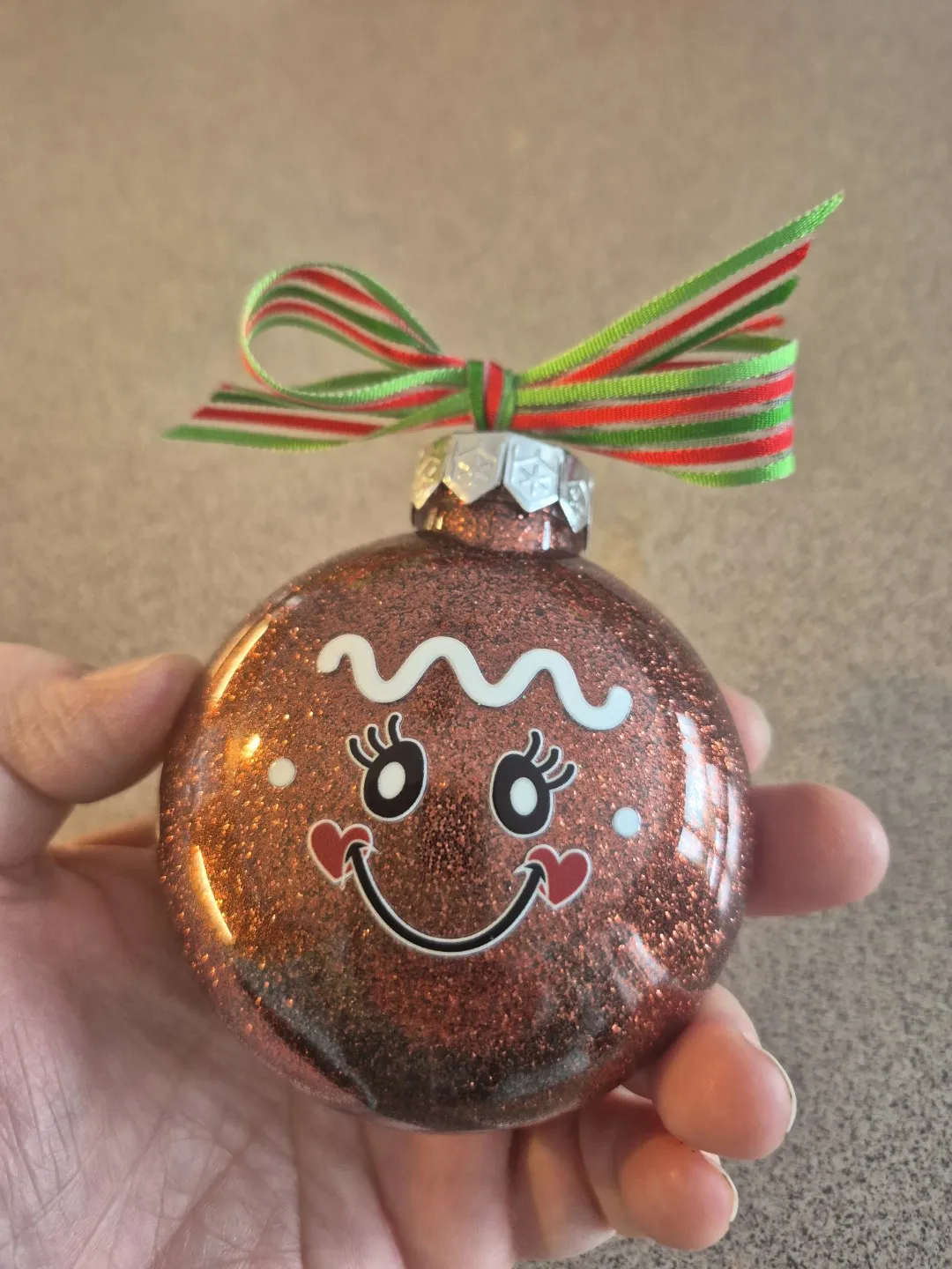 A glass ball ornament with a face. It has brown glitter inside.